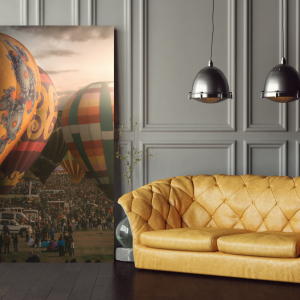 Photograph of colorful hot air balloons at a festival with a crowd of spectators.