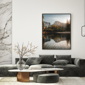 Photograph of Half Dome reflected in a calm river at Yosemite National Park, surrounded by trees.