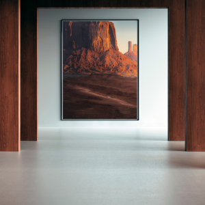 Landscape photograph of Monument Valley at sunset, featuring red sandstone buttes and a winding desert road.