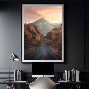 Photograph of a winding road through red rock formations with a colorful sunset in Valley of Fire State Park, Nevada.