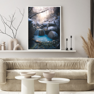 Photograph of a hot spring waterfall surrounded by snow-covered rocks and trees in Utah during winter.